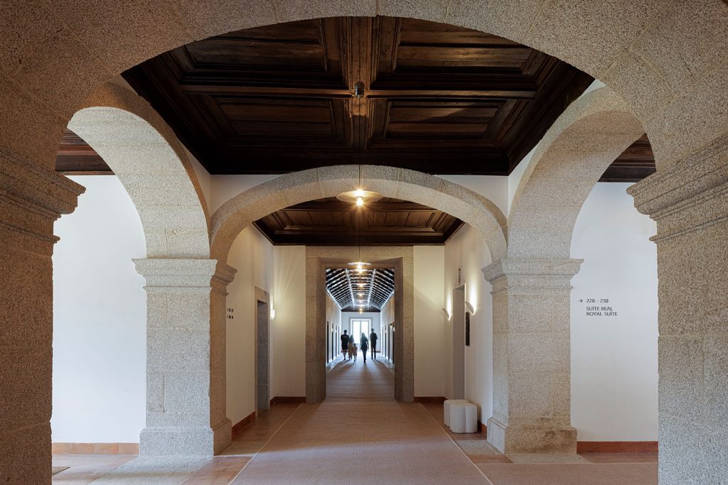 Upper corridor with stone arches and a timber ceiling