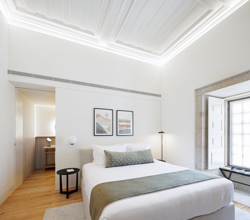 Guest bed beneath a white panelled ceiling