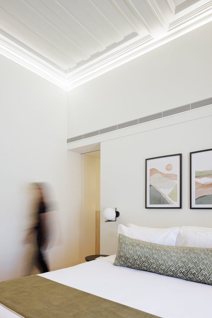 Guest room with pale walls and concealed ceiling lighting