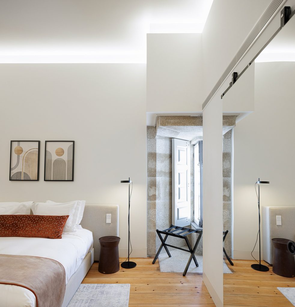 Guest room with timber flooring and a stone-framed window