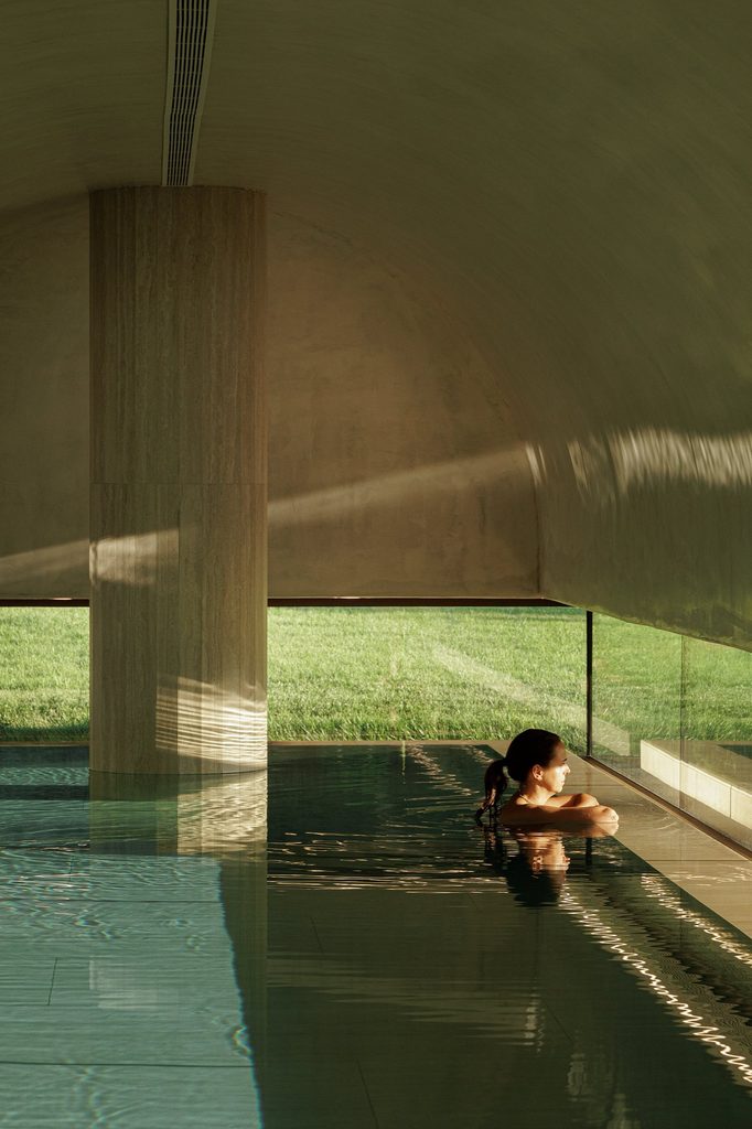 Swimmer beside the central column and low garden-facing glazing