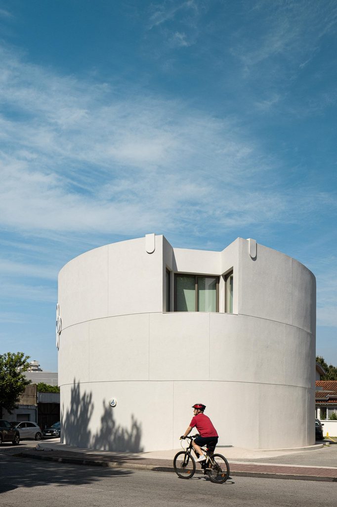 Curved white facade with a recessed upper window