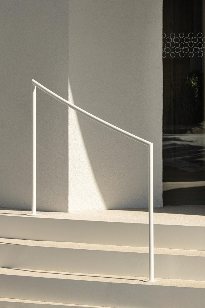 Entrance steps with a slender metal handrail