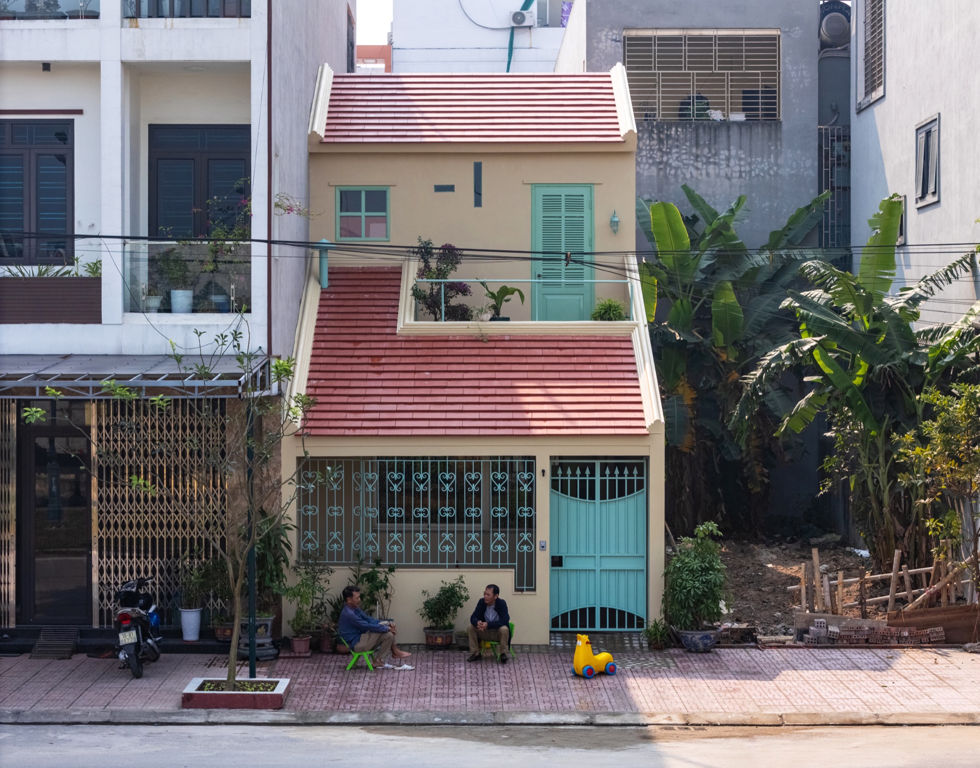 Samson House street facade with a green gate and red tiled roofs