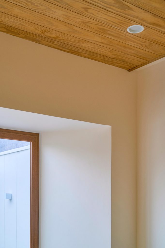 Timber ceiling meeting a white wall