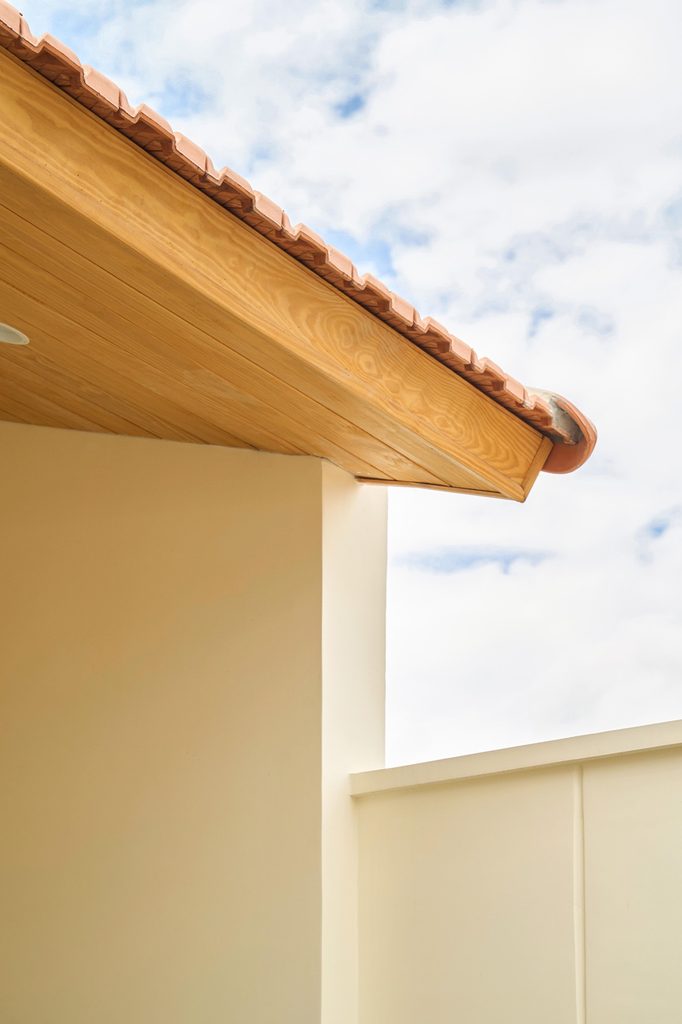 Roof eave and red tiles against the sky
