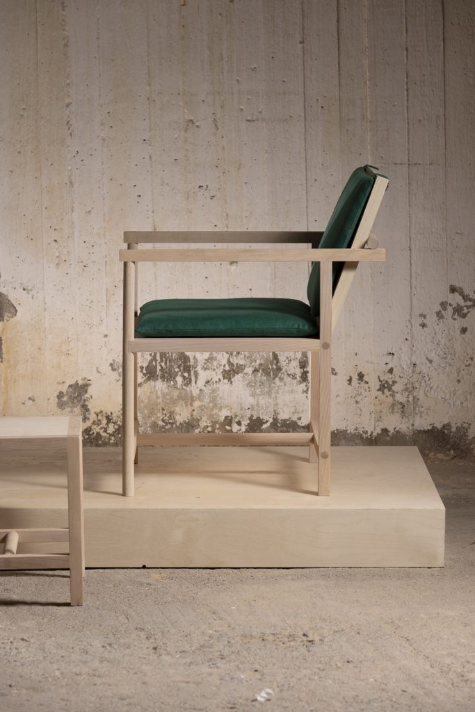 Side view of the maple Parrot Chair showing its seat and arms.