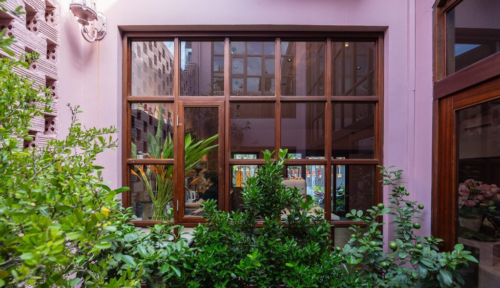 Cafe window opening toward a small courtyard garden