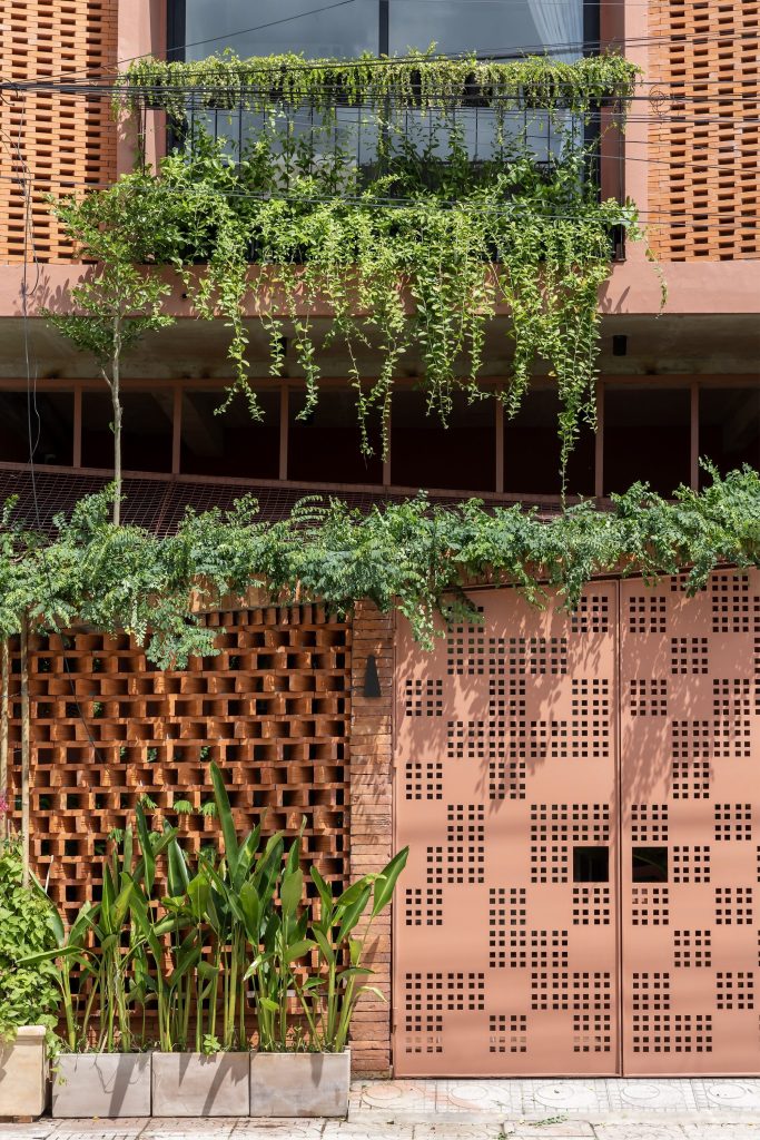 Entrance gate and brick screen beneath trailing greenery