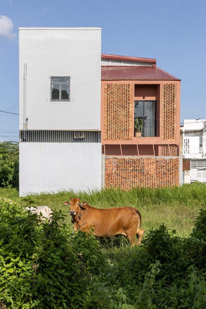 Brick-fronted house viewed across neighbouring grassland