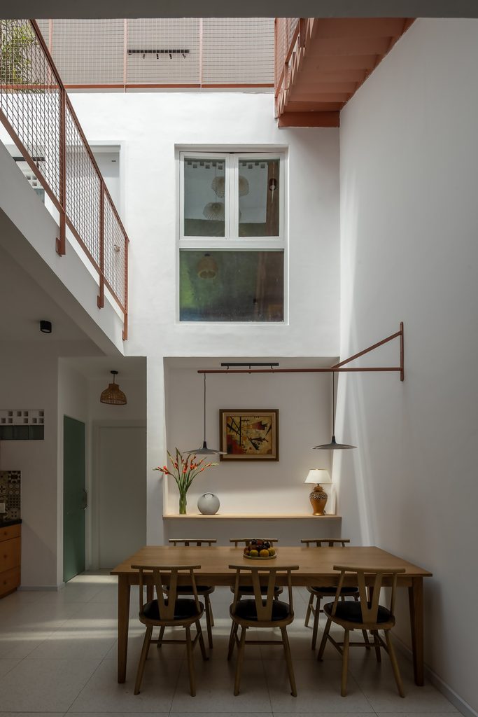 Timber dining table beneath the tall central void