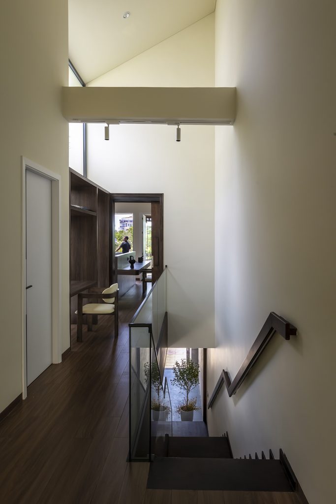 Open stair and upper corridor beneath a high window