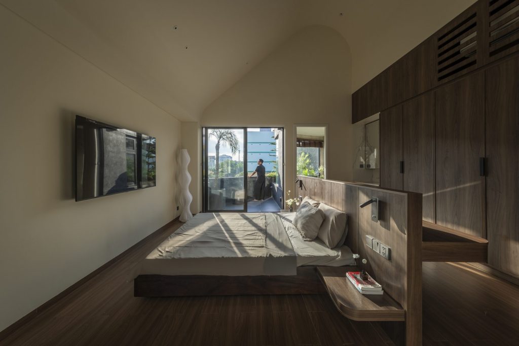 Bedroom with timber flooring and full-height cabinetry
