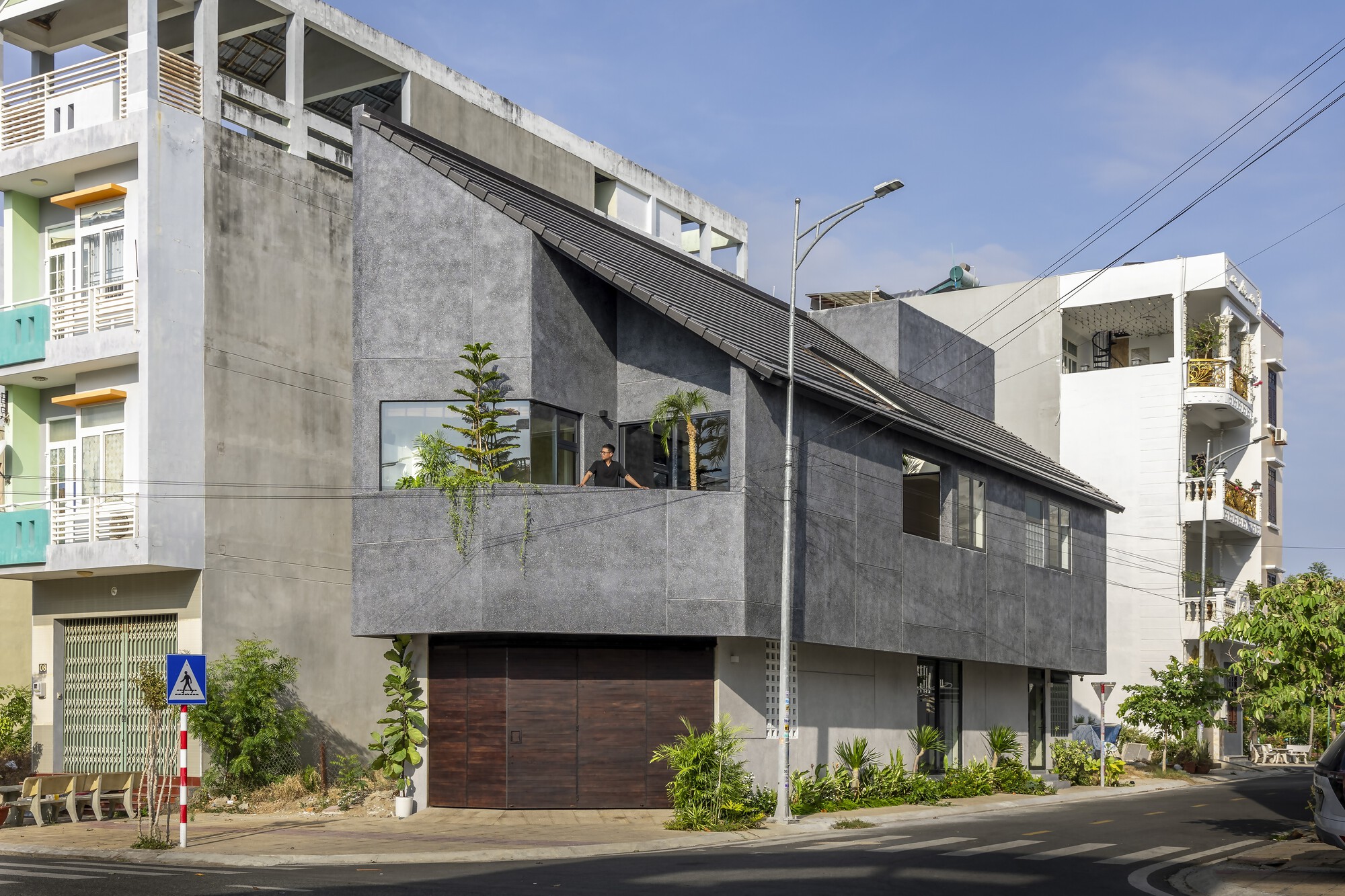 Corner view of the house with a sloping roof and recessed balcony