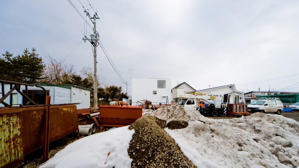 The white house seen across an industrial yard in snow