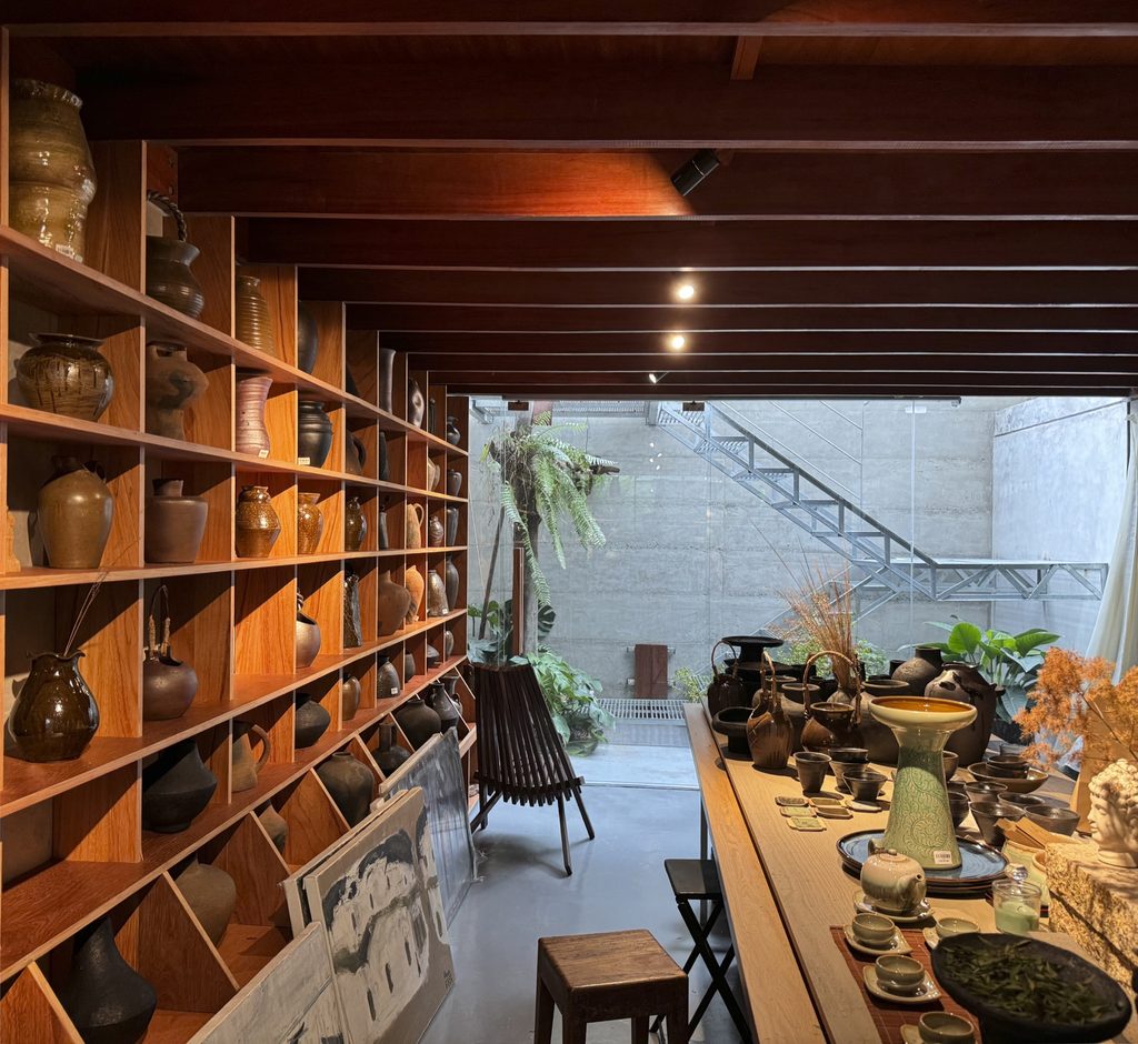 Shelves of ceramics and books around a workspace