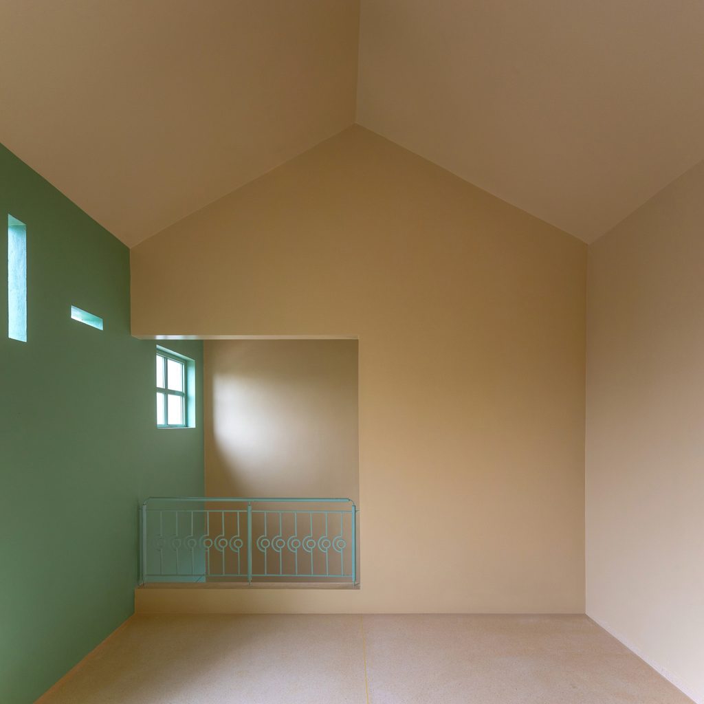 Upper room beneath a pitched ceiling with a green wall