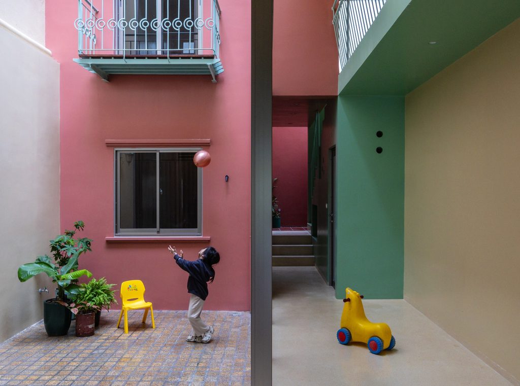 Child playing in the pink-walled courtyard
