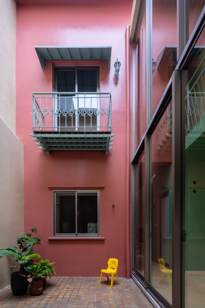 Pink courtyard wall with a small metal balcony