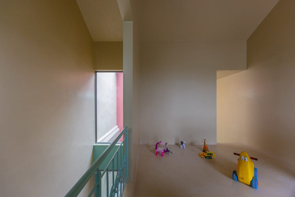 Upper landing with toys beside a green metal railing