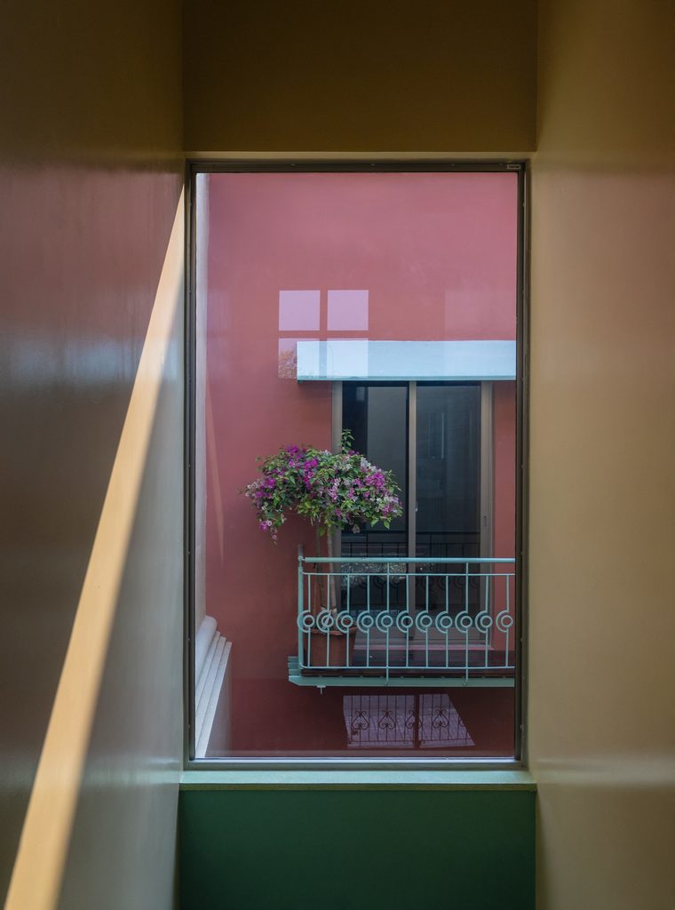Interior window framing a balcony across the courtyard