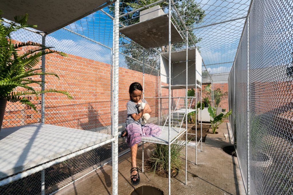 A child sitting on a box inside the coop