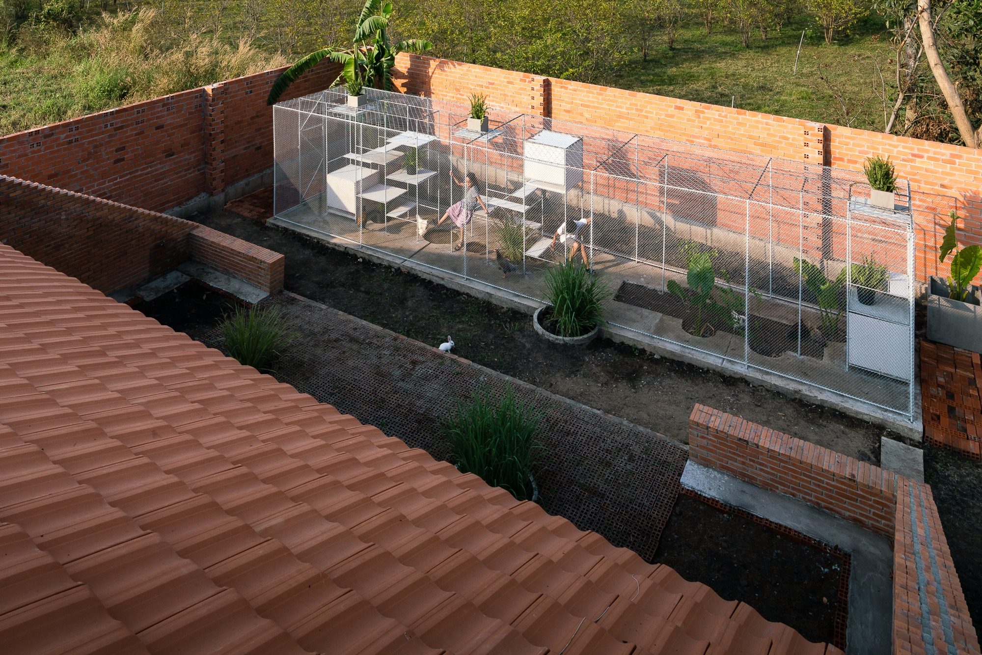 The coop seen from above beside a brick wall