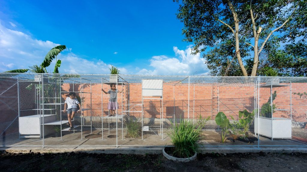 The mesh enclosure stretched along a brick garden wall