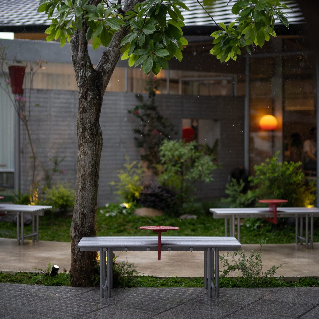 Tables under a tree in front of the café