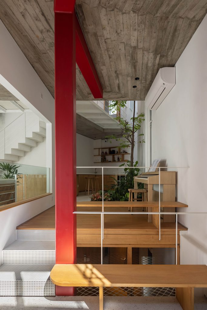 Red steel column between timber benches and an open stair
