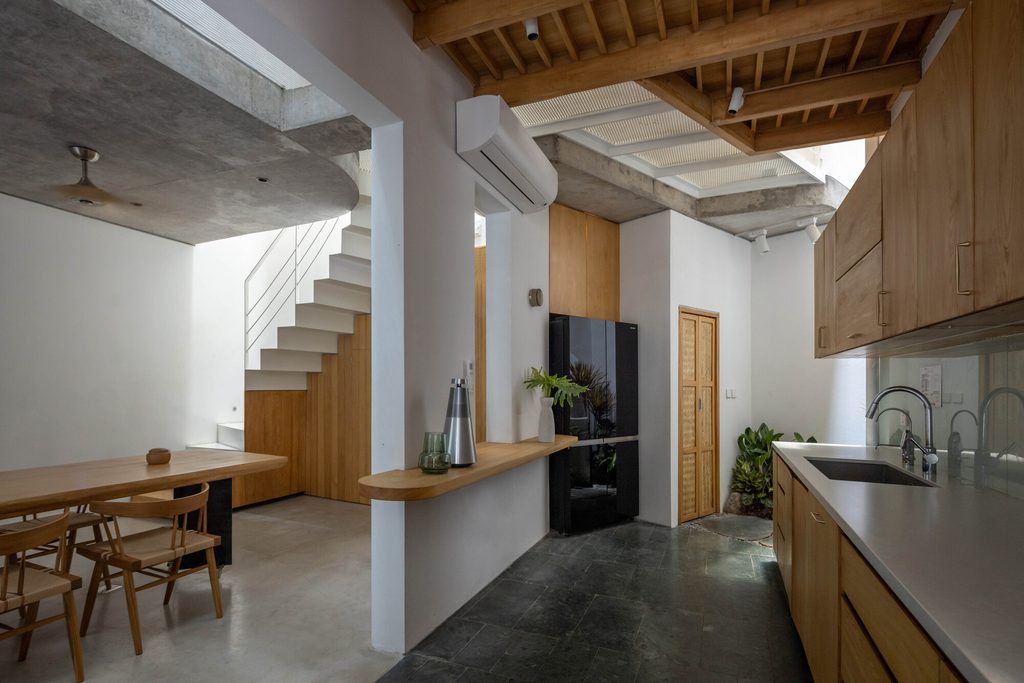Kitchen and dining room beneath timber slats and exposed concrete