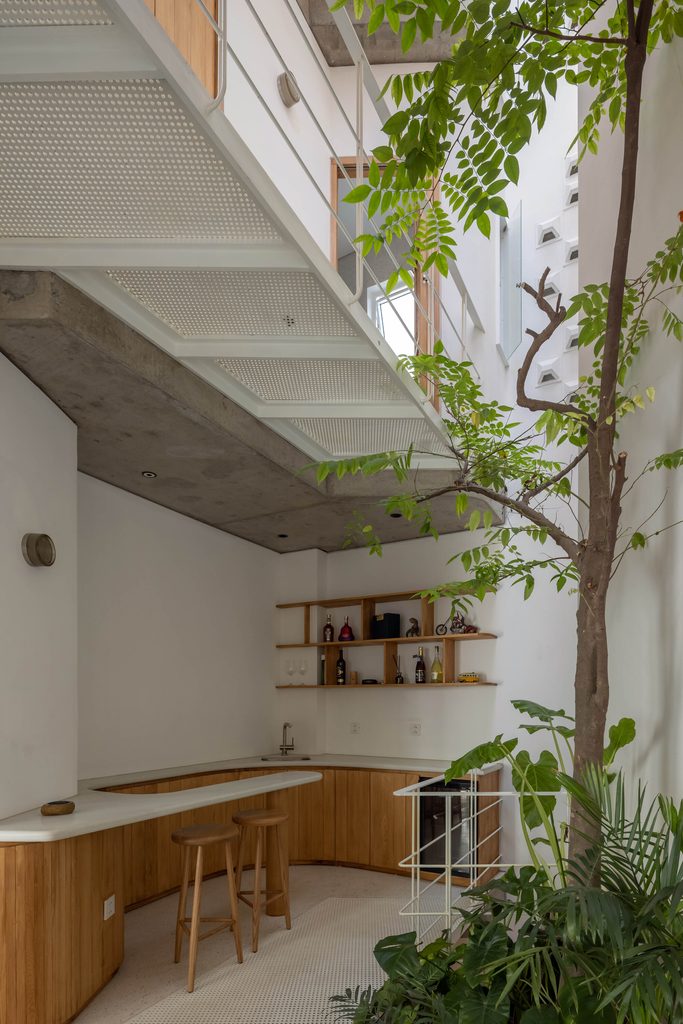 Timber counter below a white metal walkway beside a tree