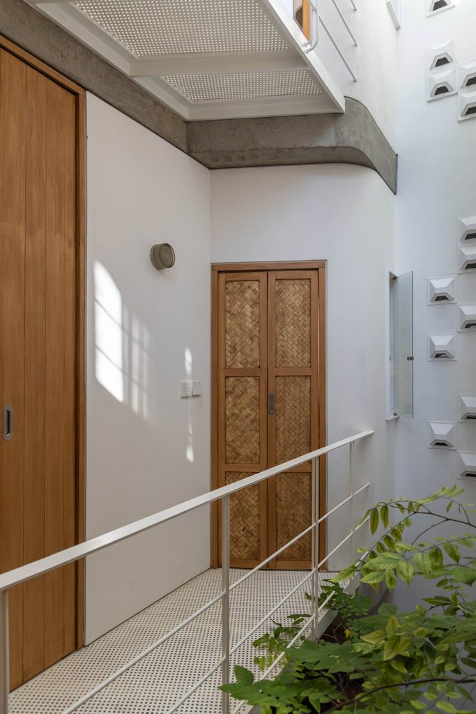 Upper walkway beside timber doors and indoor greenery