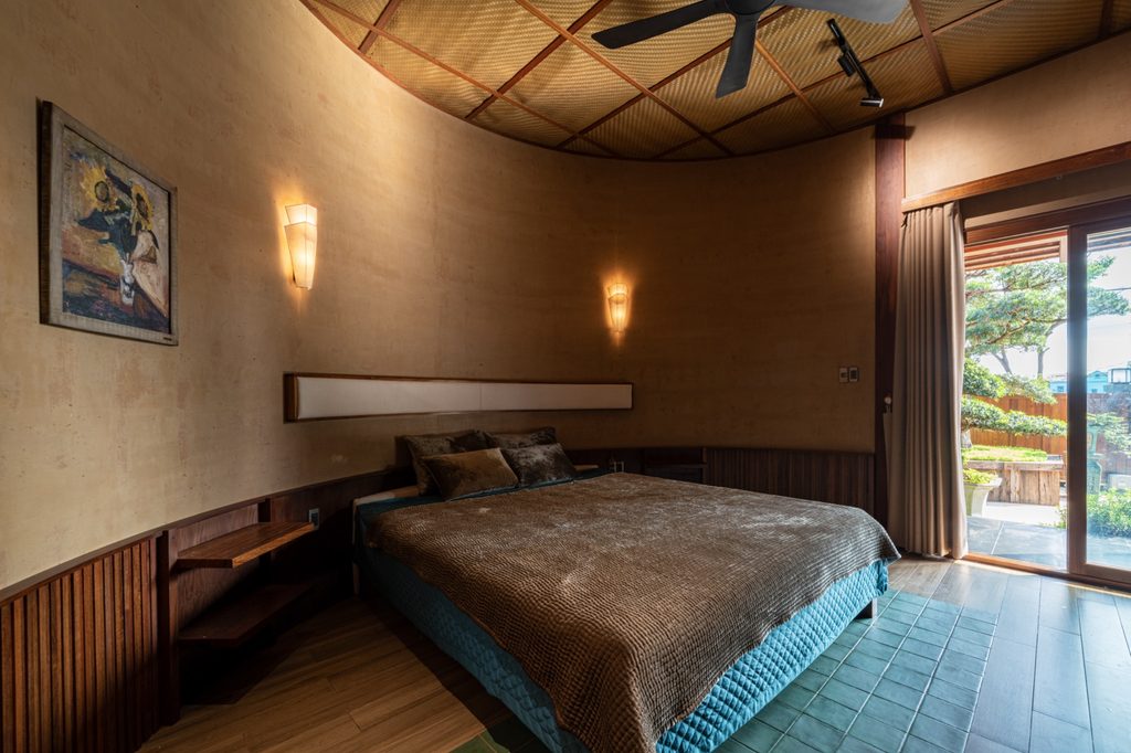 Bedroom with curved wall and timber ceiling