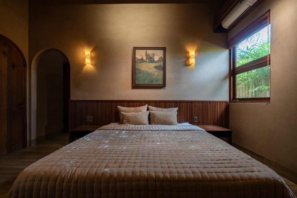 Bedroom with a round window and timber headboard
