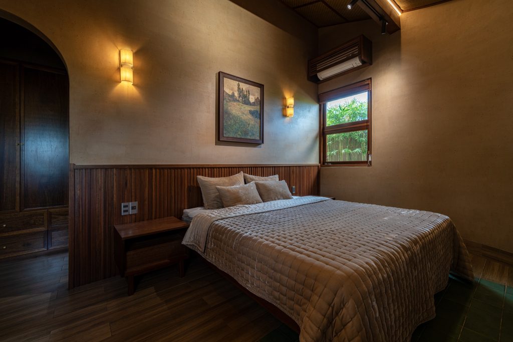 Bedroom with timber headboard and warm wall finish