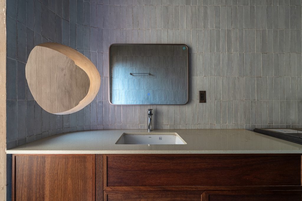 Bathroom vanity beneath a round mirror