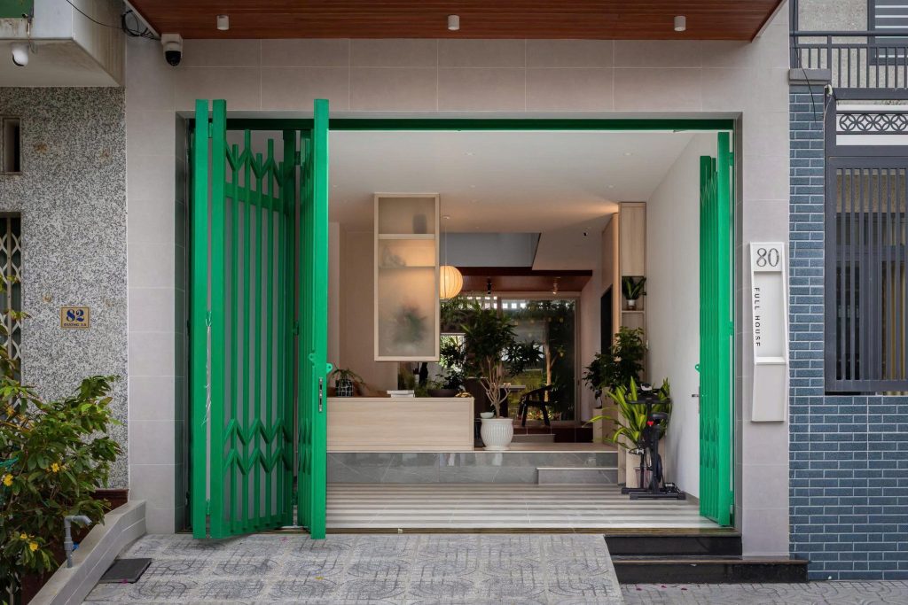 Open green entrance gates framing the living area