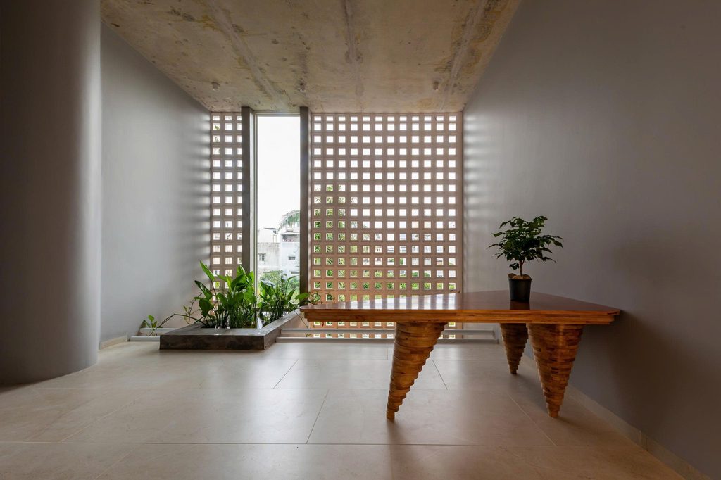Quiet room with a timber table beside a perforated screen