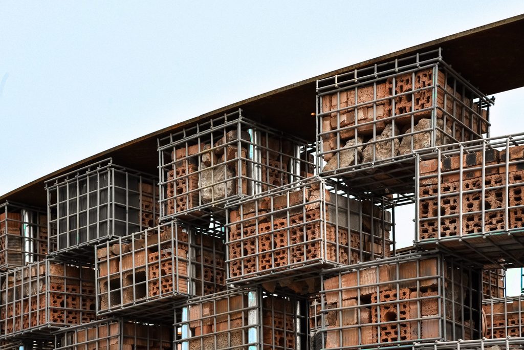Circular wall made from reused bricks in steel cages