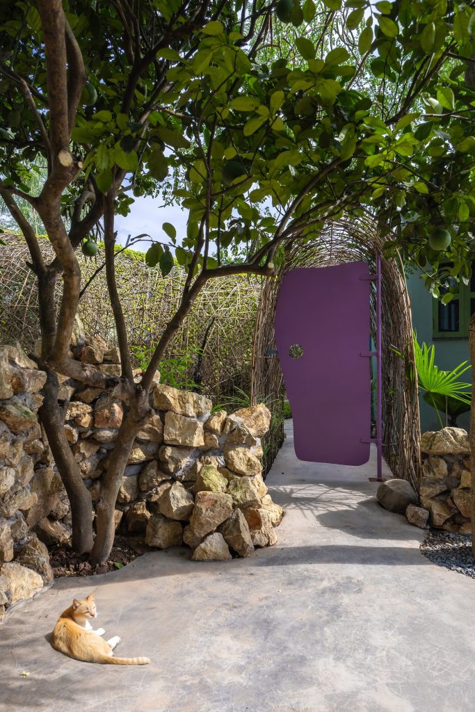 Dry-stacked stone walls leading to a violet door