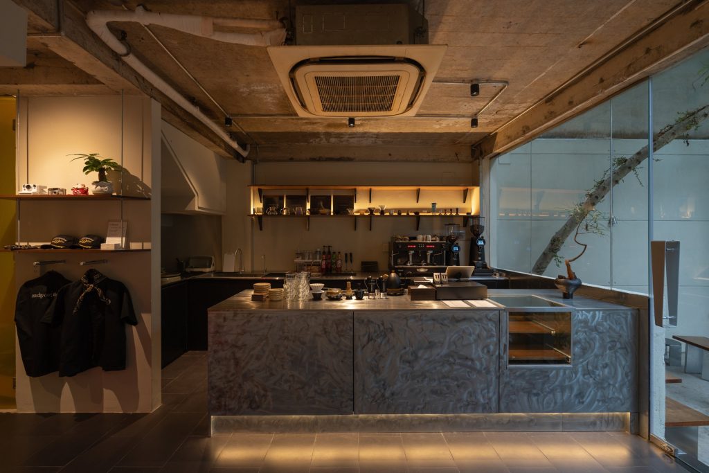 Day1 Cafe by oh.hi studio, stone bar counter with shelving behind