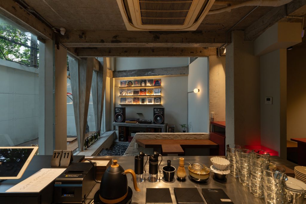 Day1 Cafe by oh.hi studio, ground floor seen across the bar toward the façade