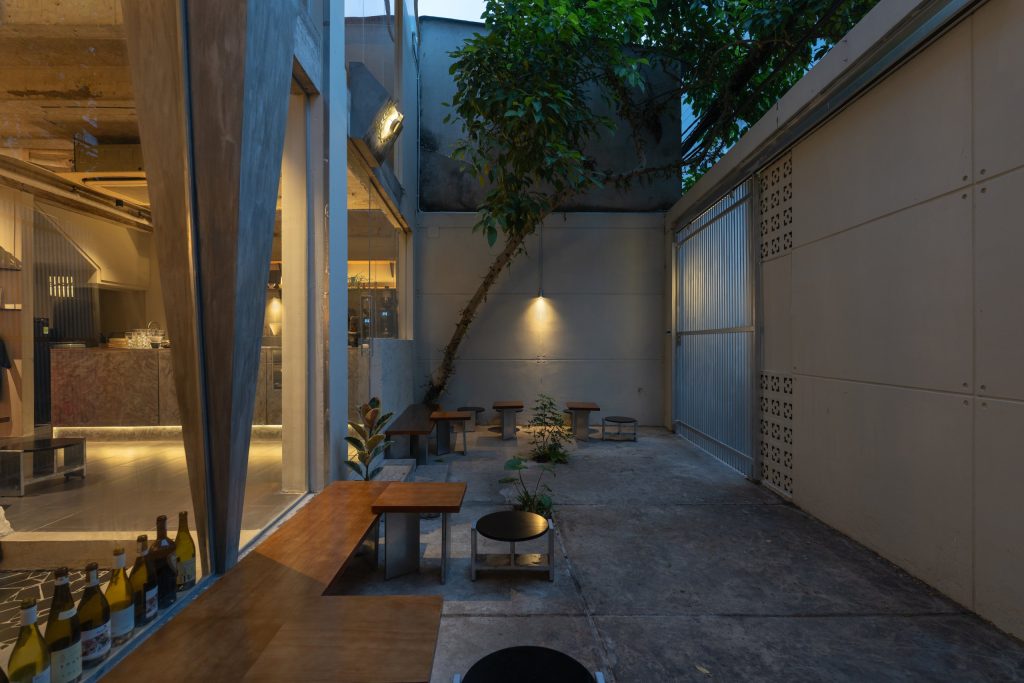Day1 Cafe by oh.hi studio, courtyard between the high masonry wall and the café