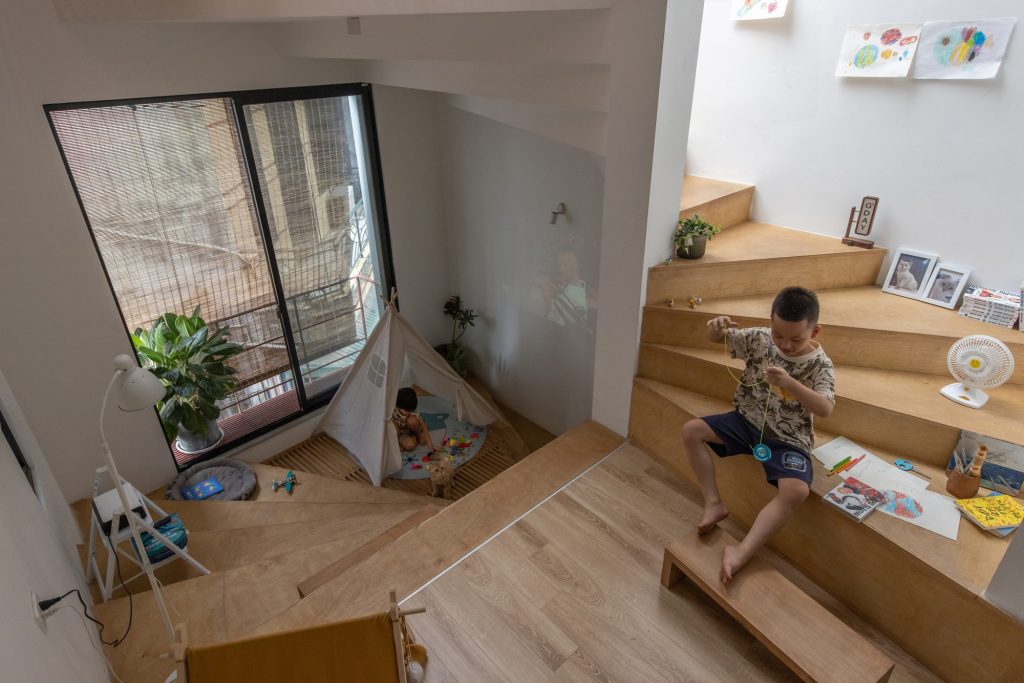 Children playing across stepped timber platforms