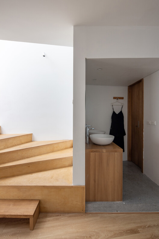 Washbasin and cabinet beside the timber staircase