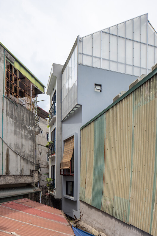 Translucent upper facade between neighboring houses