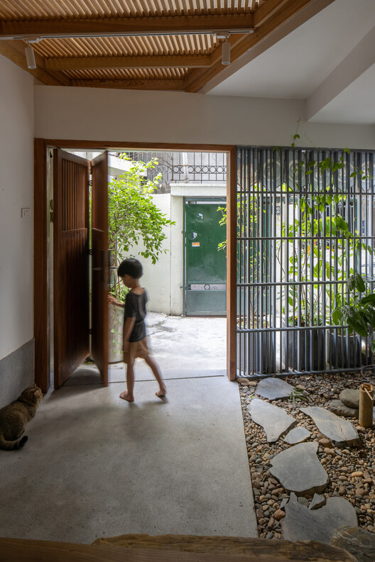 Open timber entrance beside a stone-lined courtyard
