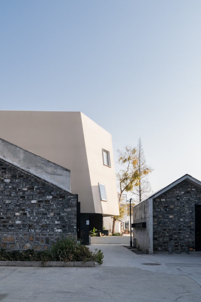 New volume rising behind retained brick houses