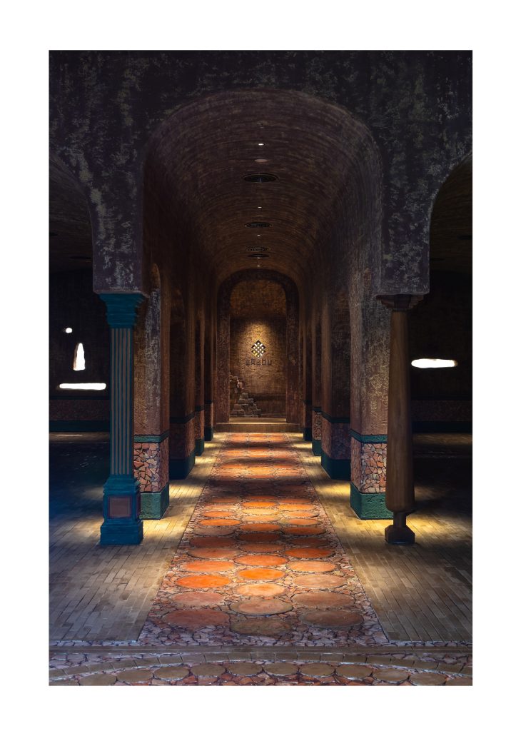 Teal-banded columns along the lit gallery